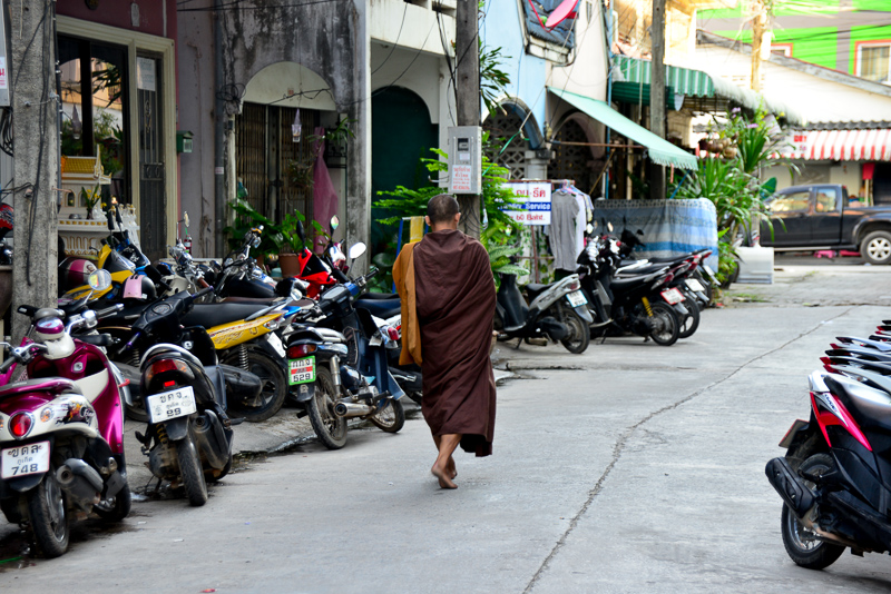A monk walks the street on his morning alms round