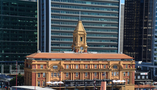The original Ferry Terminal on the waterfront in Auckland is dwarfed by the CBD.