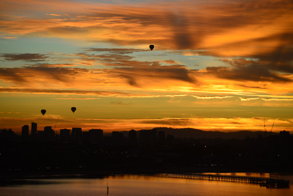 Hot air balloons dot the sunrise over Melbourne.