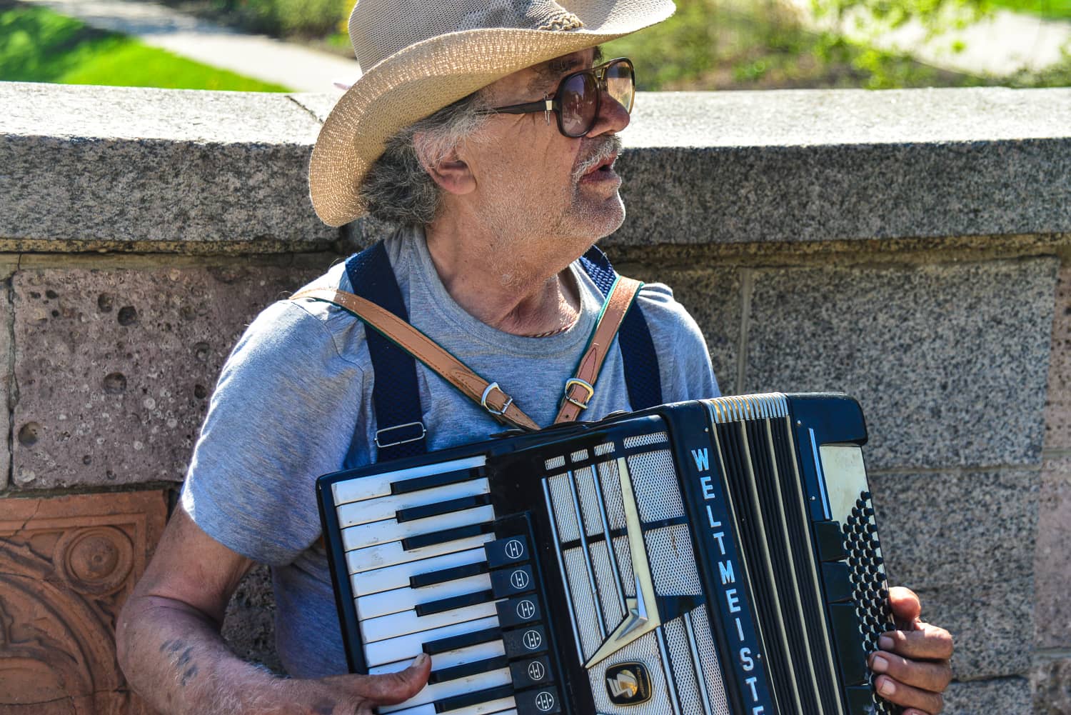 We cross the bridge into the park with an accompaniment by this busker.