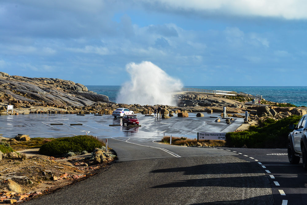 An image of the rock formation know as the Gap with a huge wave crashing ove the car park.