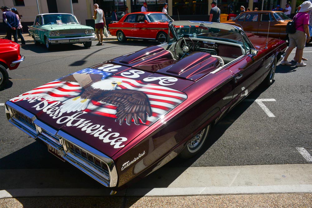Image of a classic thunderbird convertable decorated with God Bless America.